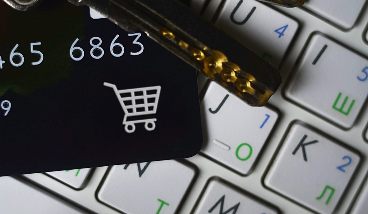 Online shopping. Credit card and keys on white laptop keyboard. E-commerce